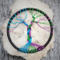 small tree is displayed against q chunk of quartz crystal showcasing the colorful tree
